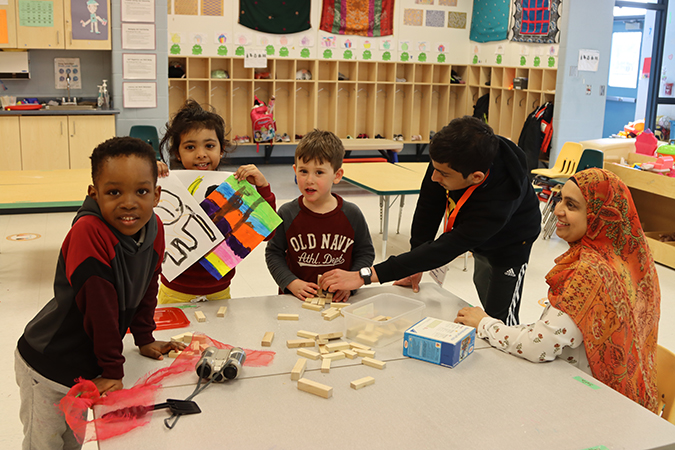 children, volunteer and staff play Jenga